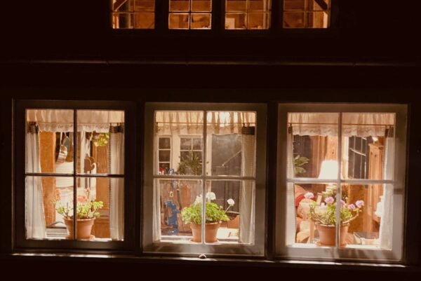 view looking into the Kitchen Window in Carriage House at Night.||Peaceful scene of Bedroom area in the Carriage House showing Oriental rug on a wooden floor