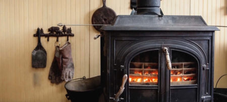 black woodburning stove on a cozy porch glowing orange from the fire within